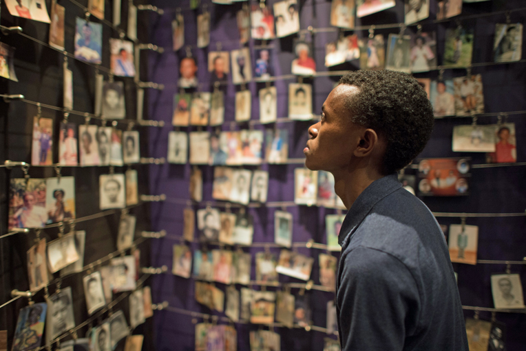 Alex looks at photos of genocide victims on display at Kigali Genocide Memorial Center.