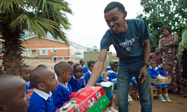 Alex distributes shoeboxes at the orphanage in Kigali where he grew up, Gisimba Memorial Center.