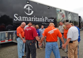 Staff and volunteers pray before heading out to help homeowners impacted by the floods.