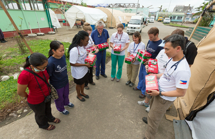 Samaritan’s Purse doctors and nurses providing emergency medical relief in the aftermath of Super Typhoon Haiyan pray over Operation Christmas Child shoebox gifts. These were given as a surprise to boys and girls who are recovering in our field hospital.