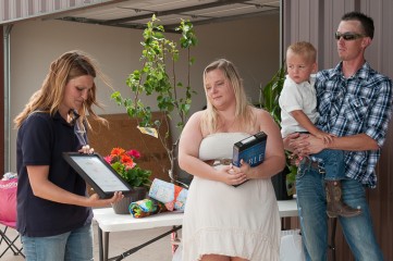 Karen Neupauer presents the Paid in Full plaque to the Hopkins family before they move into their new home.