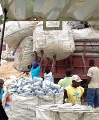 Men lift recyclable materials onto a truck.