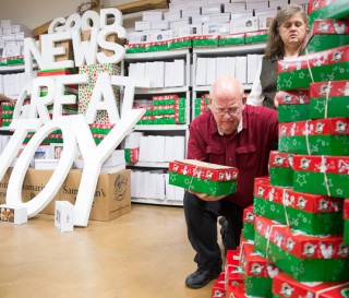 Cherry and Mark Brumbelow pray over Operation Christmas Child shoeboxes during a service at Grace Baptist Church.