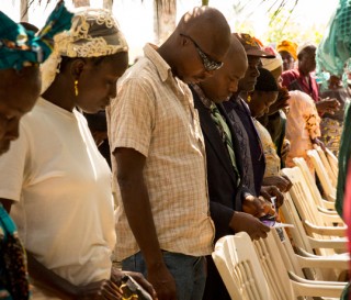 Participants at the Ebola Memorial Cemetery dedication in Foya, Liberia, join together in prayer.