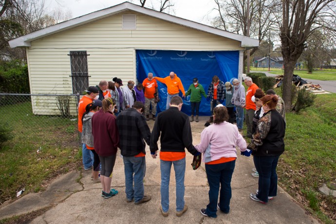 Samaritan's Purse volunteers pray before working on the home of Emma Lee Sanders.