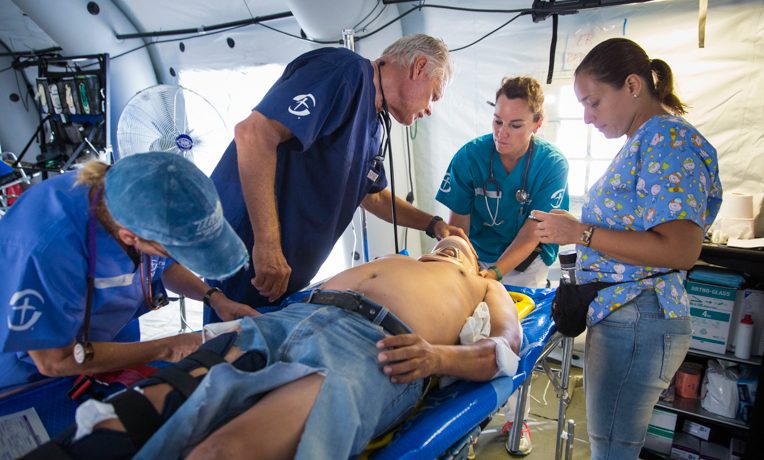 Medical staff work on a patient at the Samaritan's Purse emergency field hospital in Chone, Ecuador. Physician Mabel Lojan is at far right.