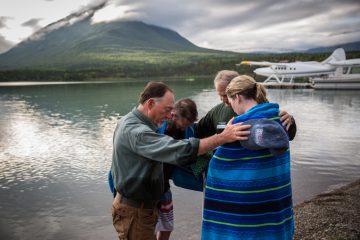 Chaplains Jim Fisher (left) and Dan Stephens pray with Phil and Jenny Quintana after their baptism.