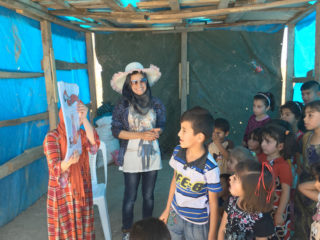 Boys and girls displaced from Mosul listen intently to a hygiene presentation during one of the center’s mobile clinic visits.