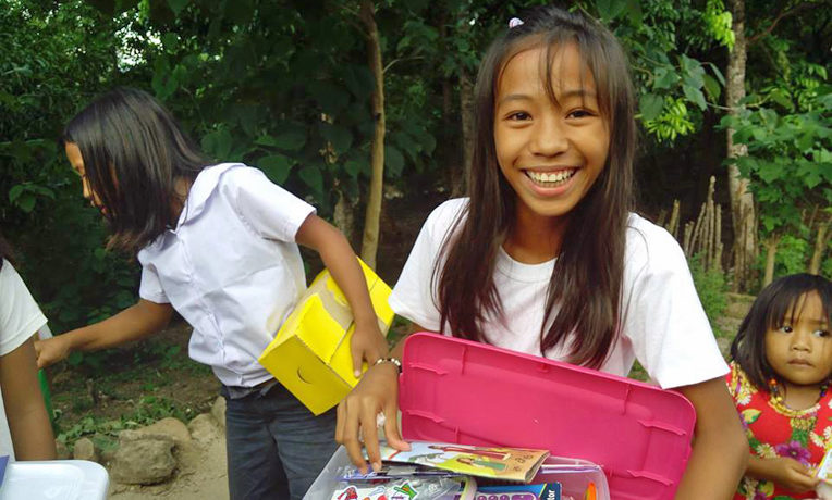 Girl in the Philippines with Operation Christmas Child shoebox