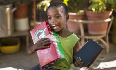 A young boy in Namibia receives an Operation Christmas Child shoebox that contains a Bible