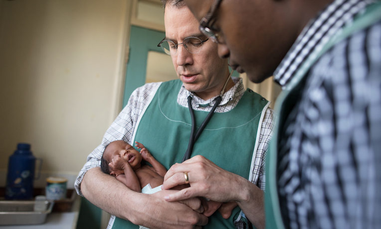 Dr. Steven Roskos provides a loving touch to a baby born prematurely at Chogoria Hospital, Kenya.