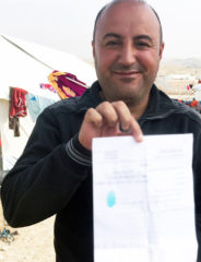 Ammar holds a copy of the ISIS sentencing—55 lashes—that was given to him and his relatives. This copy was his cousin's and the Arabic has been blurred for security.