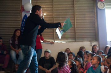 Daniel leading children through The Greatest Gift Gospel presentation. 