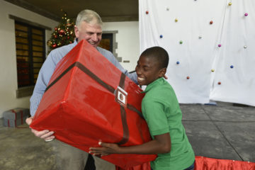 Franklin Graham gives a Christmas present to one of the Greta Home children.