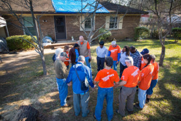 Volunteers praying with homeowners 