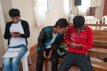 Wilfredo, 24, looks up discipleship material on his mobile phone while 18-year-old Wilfredo looks at his friend Eusebio’s phone.