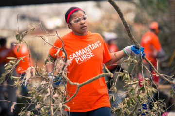 A Samaritan's Purse volunteer helps clean up debris at Shirley Payton's home.