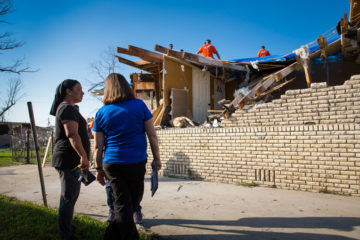 Keisha Westbrook talks with a Rapid Response Team chaplain as Samaritan's Purse volunteer work on her roof.