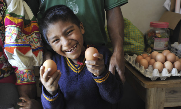 Andy, 7, proudly shows off the eggs his parents sell at their store.