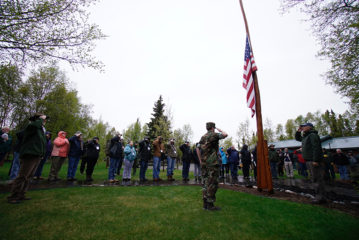Retired military chaplain Jim Fisher led a special remembrance ceremony on Memorial Day to honor U.S. military personnel who have given their lives in defense of the nation. Retired General Jim Walker (front right), executive director of Operation Heal Our Patriots, raised the flag this morning and set it at half-mast alongside Civil Air Patrol cadet Paul Quebman (front, in unform) as Week 1's nine couples saluted. Quebman, 16, is an Anchorage high school student serving this week at nearby Tanalian Bible Camp. 
