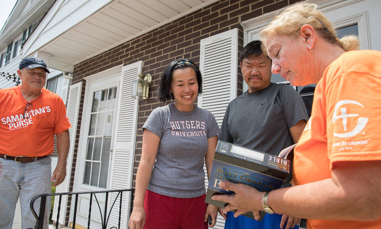 Samaritan's Purse volunteers present a Bible to homeowners Sasa and Yun in Libertyville, Illinois.