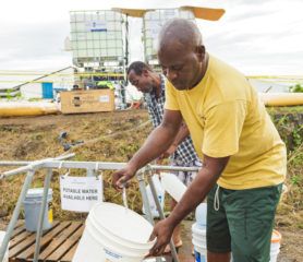 Wendell Lawrence fills a container with clean drinking water.