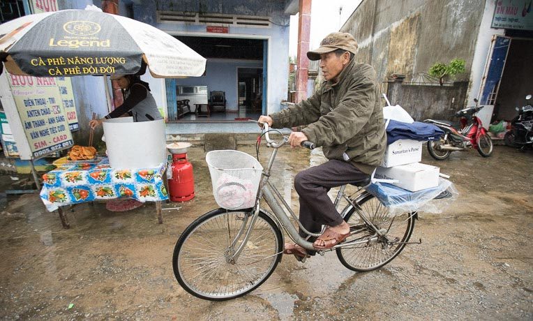 Ngoc Nhu Phan peddles his supplies by bike to his home on Tam Hai Island.
