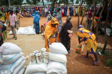 Refugees collect food rations during a distribution in their camp. 