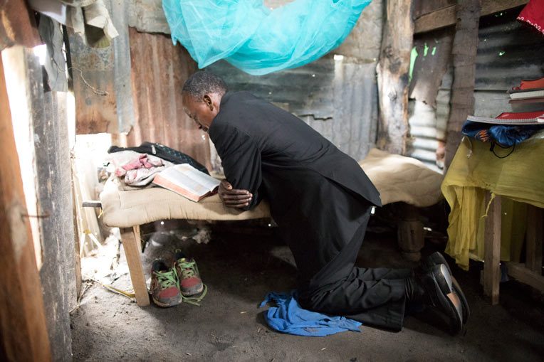 El pastor Marco Kayumbo ora en su estudio y lugar de residencia, donde duerme cuando visita Kitomondo.