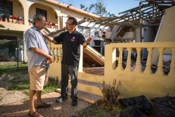 Pastor Miguel Ortiz encourages a homeowner who received a generator and tarp from Samaritan's Purse. 