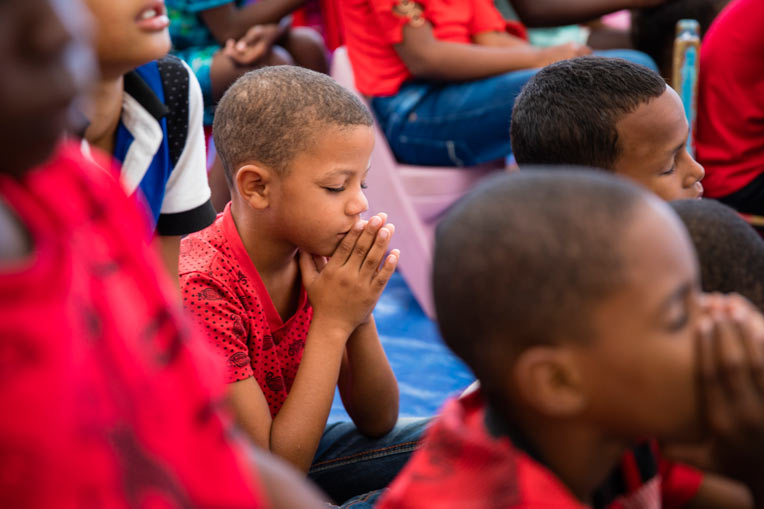 Boy praying at Operation Christmas Child event