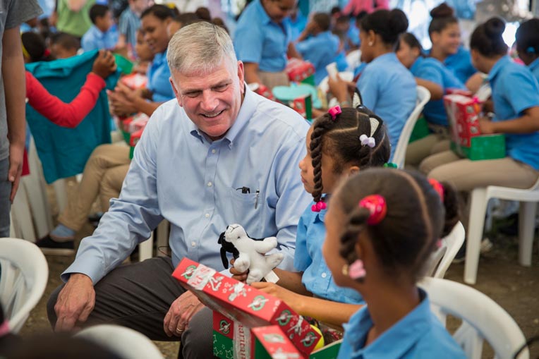 Franklin Graham shares a moment with Rossanny, 9, as she opens her shoebox gift