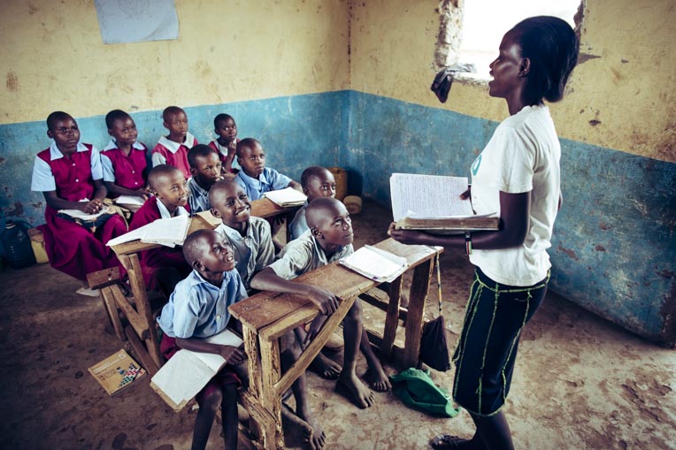 A Kenyan teacher talks with her students.