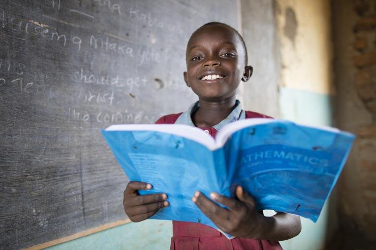 Student holds a mathematics books at Makuuni Primary School in Kenya