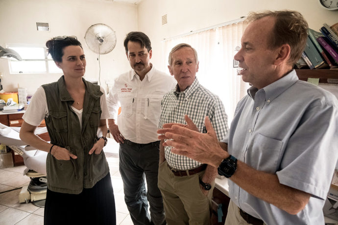 Cissie Graham Lynch (left), Dr. Lance Plyler, and Dr. Richard Furman talk with at Chitokoloki Hospital in Zambia. 