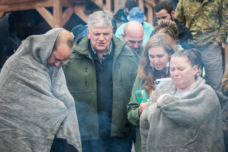 Samaritan's Purse President Franklin Graham prays with military couples after their baptism.