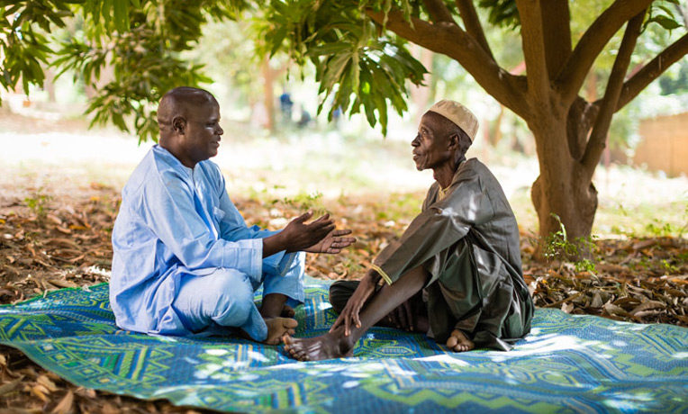 Abdou Issa and Ibrahim Sani discuss scripture under a mango tree. Ibrahim was led to salvation in Jesus Christ after Abdou preached the Gospel in his village.