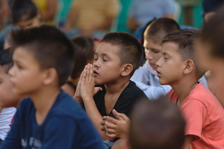 Children pray during the distribution. 