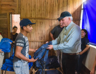 Franklin Graham helps distribute Samaritan's Purse backpacks filled with daily essentials.