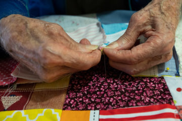 Even at age 98, Theron’s steady hands pin together pieces of a quilt.