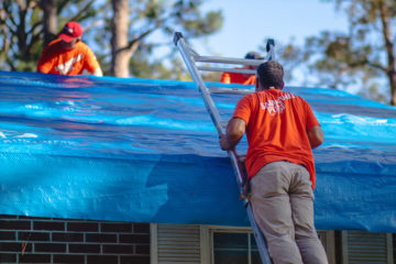 Volunteers tarp the roof of Raymond and Eula Best after it was damaged during Hurricane Michael.