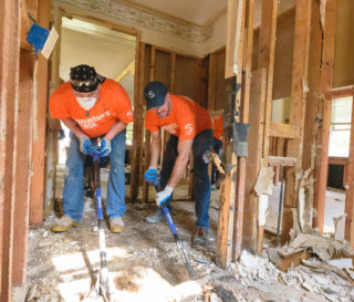 Samaritan's Purse volunteers dig out ruined flooring at the home of Love Whitfield.