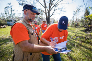 Darren Beers gathers with volunteers to sign a special Bible for homeowners in Florida.