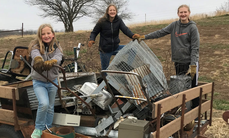 Naomi, Claira, and Hope Dannefer are blessing people in need by giving through the Samaritan's Purse gift catalog. Claira, right, collected and sold scrap metal to raise money for projects such as cleft lip and cataract surgeries, water filters, dairy goats, and blankets.