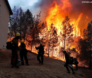 A group of U.S. Forest Service firefighters monitor a back fire while battling to save homes at the Camp Fire in Paradise, California.