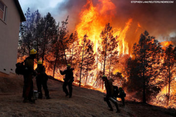 A group of U.S. Forest Service firefighters monitor a back fire while battling to save homes at the Camp Fire in Paradise, California.