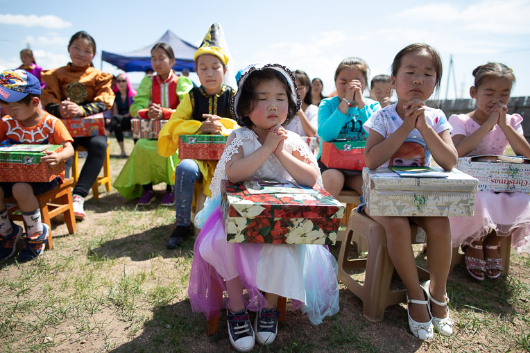 Children in Batnorov, Mongolia, pray before opening their gift-filled shoeboxes.