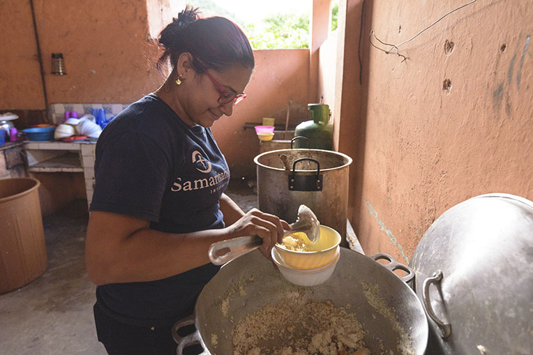 Viviana Paez prepares for food for migrants who stop at the shelter.