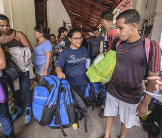 Viviana Paez distributes backpacks to Venezuelans migrants in La Don Juana, Colombia.