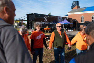 Mike Robinson (in green) prays with his team of volunteers before starting a day of service with Samaritan’s Purse.